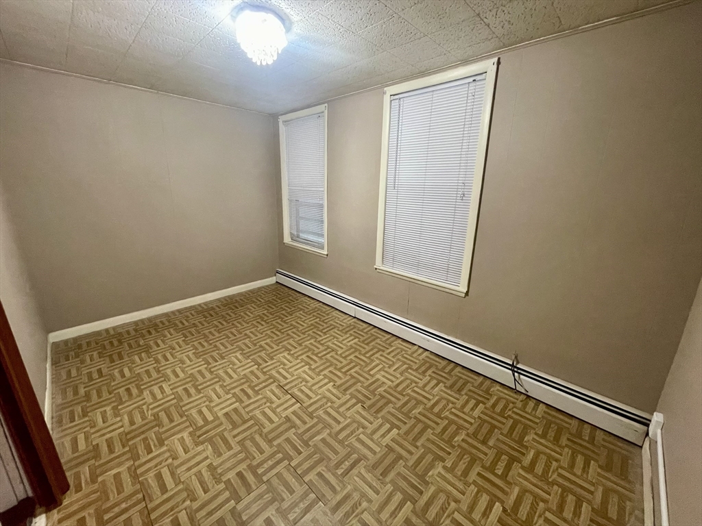 136 Saratoga Street, Unit 2 Boston, MA 02128 - Photo 13 of 19 an empty room with wooden floor and windows