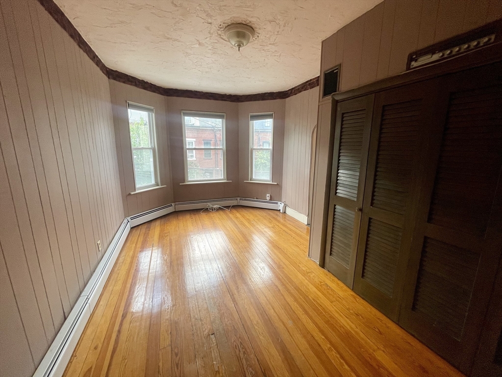 136 Saratoga Street, Unit 2 Boston, MA 02128 - Photo 2 of 19 a view of empty room with wooden floor and fan