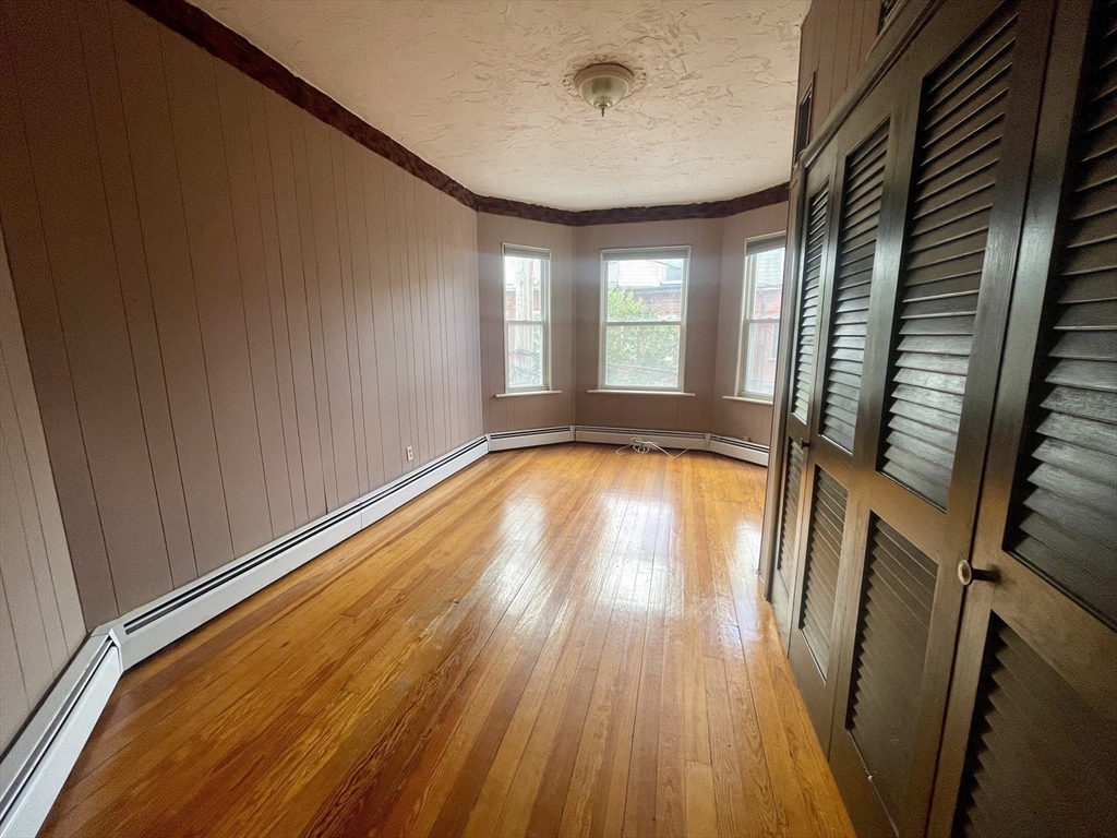 136 Saratoga Street, Unit 2 Boston, MA 02128 - Photo 4 of 19 a view of an empty room with wooden floor and a window