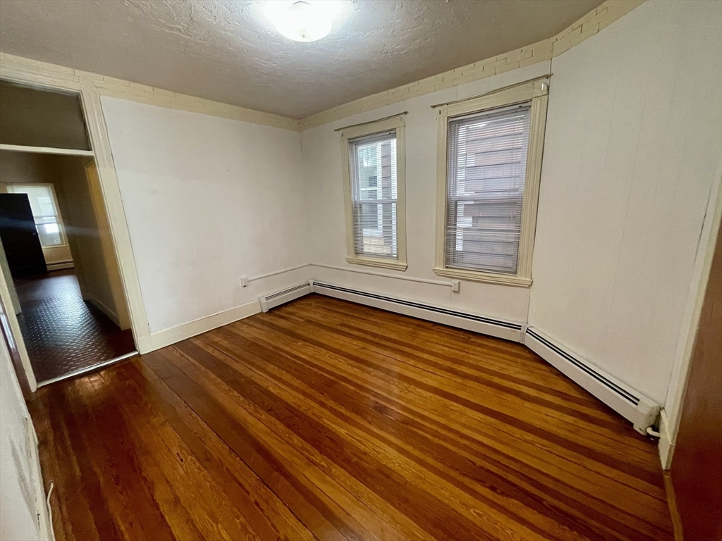 136 Saratoga Street, Unit 2 Boston, MA 02128 - Photo 9 of 19 a view of an empty room with wooden floor and a window
