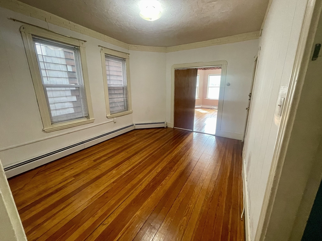 136 Saratoga Street, Unit 2 Boston, MA 02128 - Photo 10 of 19 a view of an empty room with wooden floor and a window