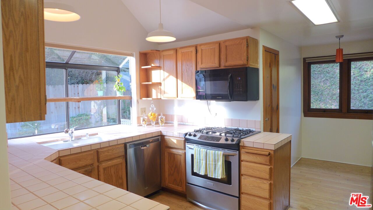 3124 Veteran Avenue Los Angeles, CA 90034 - Photo 17 of 23 a kitchen with stainless steel appliances granite countertop a sink a stove a microwave a counter top space and cabinets