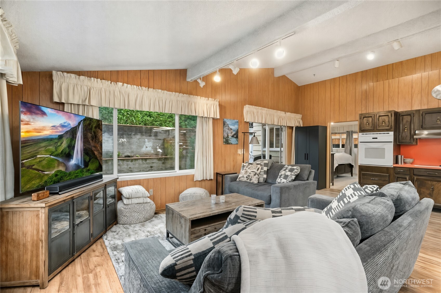 3542 43rd Avenue West Seattle, WA 98199 - Photo 6 of 39 a living room with furniture a flat screen tv and floor to ceiling window