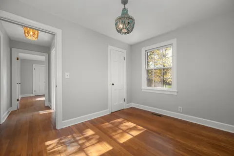 a view of a room with wooden floor and window