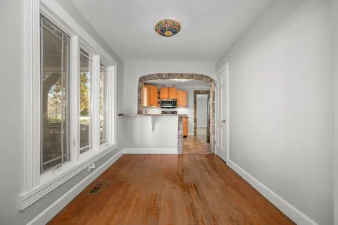 a view of a room with wooden floor and a window