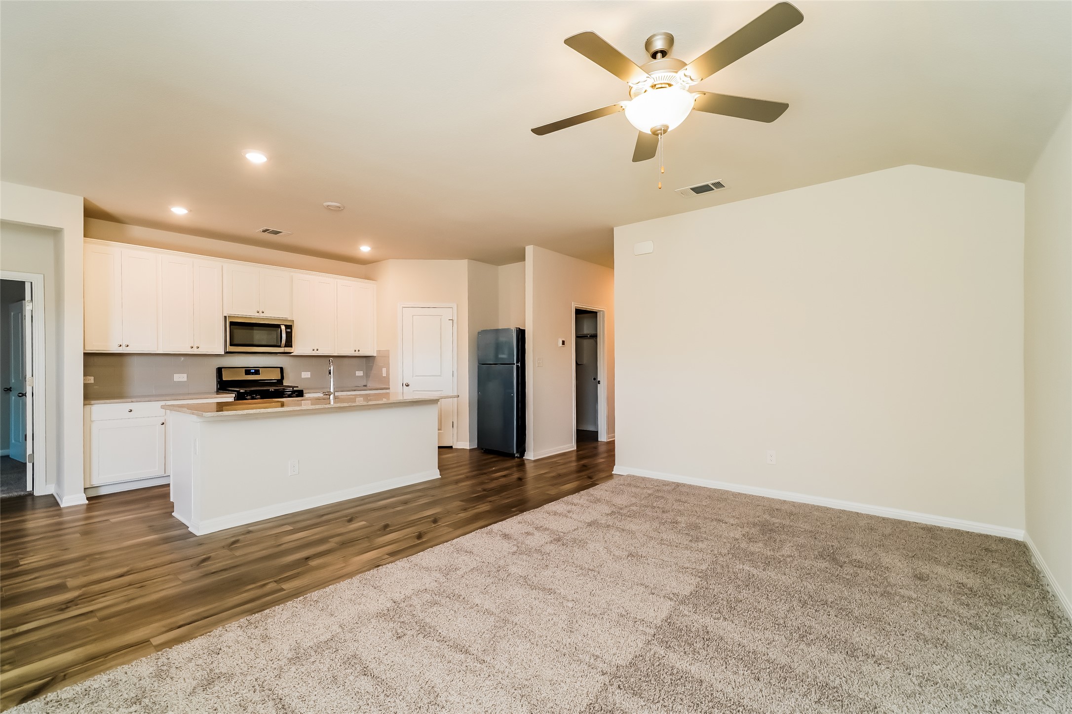 200 Babblebrook Way Hutto, TX 78634 - Photo 4 of 16 a view of kitchen with stainless steel appliances refrigerator stove microwave and cabinets