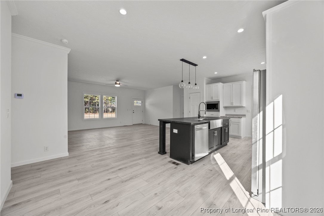 849 Loop Road Bunnlevel, NC 28323 - Photo 13 of 39 a kitchen with stainless steel appliances kitchen island granite countertop a refrigerator a sink dishwasher a stove with wooden cabinets and floor