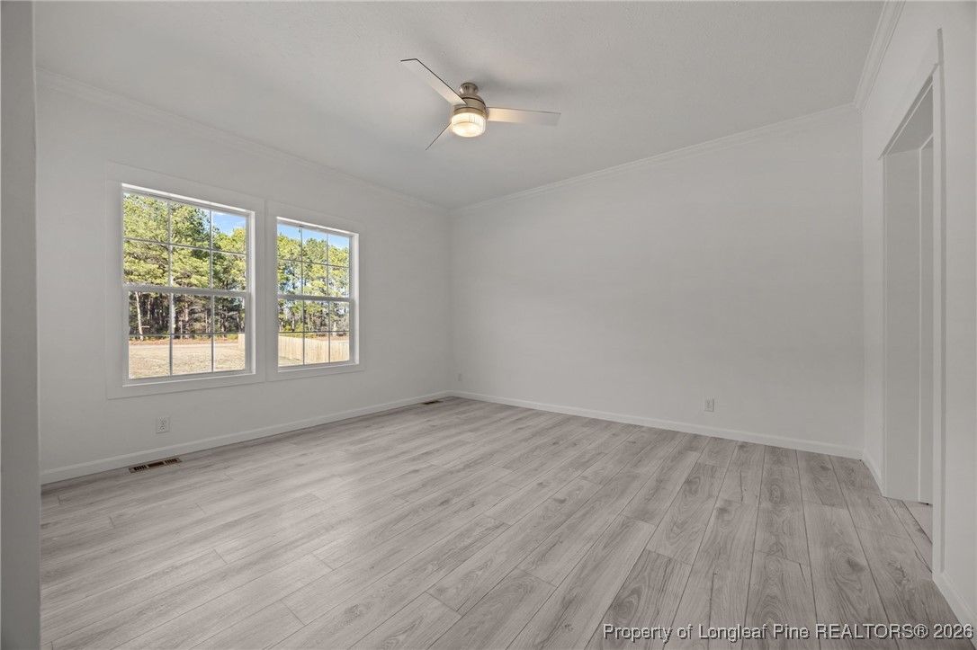 849 Loop Road Bunnlevel, NC 28323 - Photo 16 of 39 an empty room with wooden floor and windows