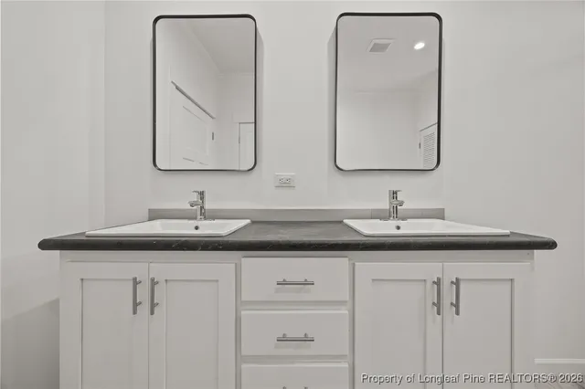 a bathroom with double sink and a mirror