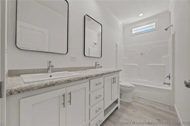 a bathroom with a granite countertop sink a toilet and a bathtub