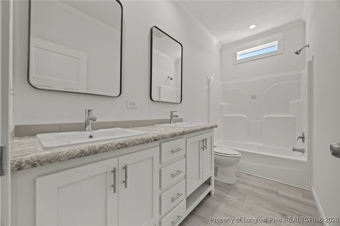849 Loop Road Bunnlevel, NC 28323 - Photo 23 of 39 a bathroom with a granite countertop sink a toilet and a bathtub