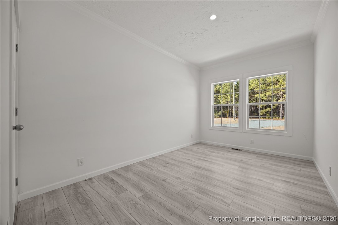 849 Loop Road Bunnlevel, NC 28323 - Photo 29 of 39 an empty room with wooden floor and windows