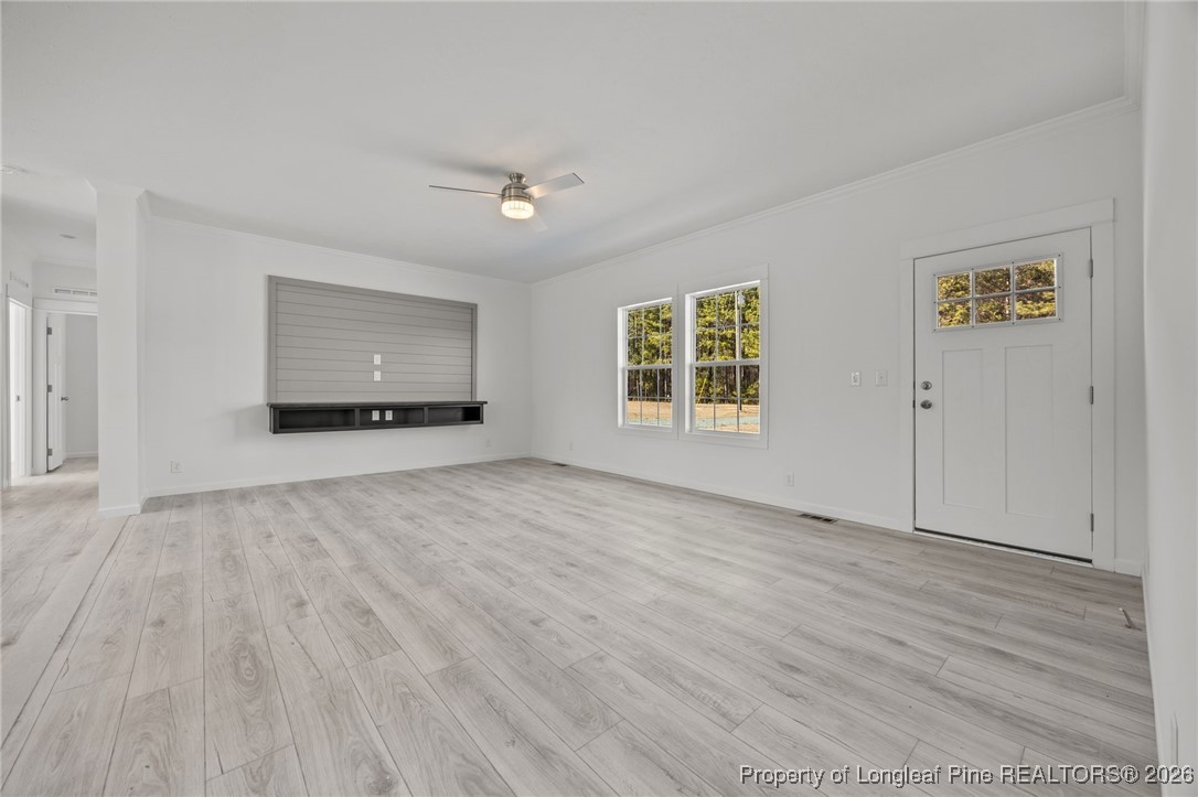 849 Loop Road Bunnlevel, NC 28323 - Photo 3 of 39 an empty room with wooden floor and windows