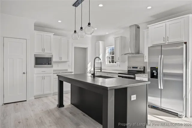 a kitchen with kitchen island a sink stainless steel appliances and cabinets