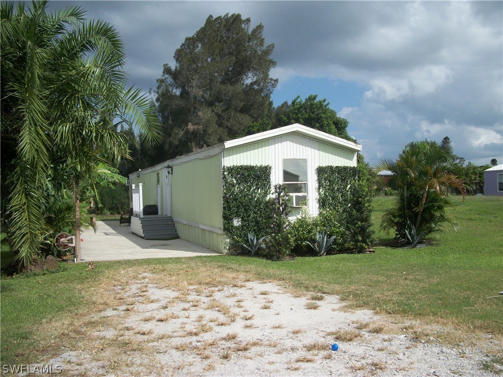 1002-1009 Nalls Road Clewiston, FL 33440 - Photo 12 of 19 a front view of a house with garden