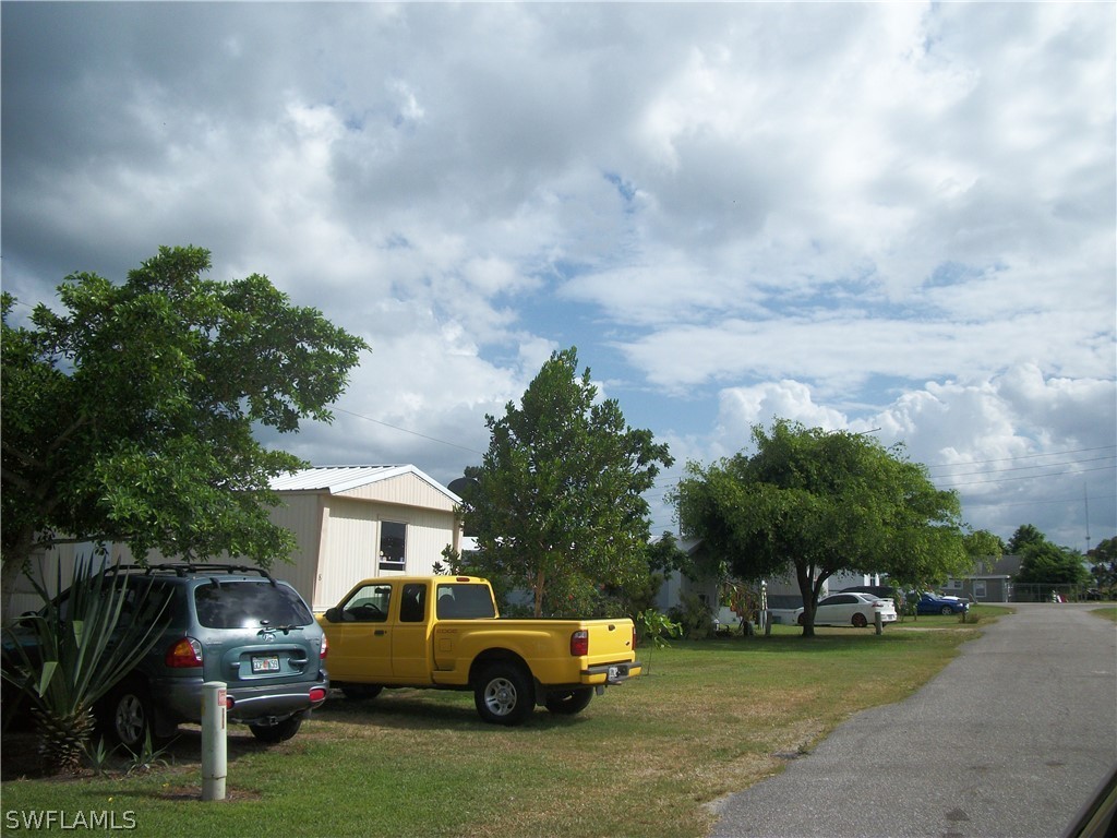 1002-1009 Nalls Road Clewiston, FL 33440 - Photo 17 of 19 a front view of a house with garden and car parked