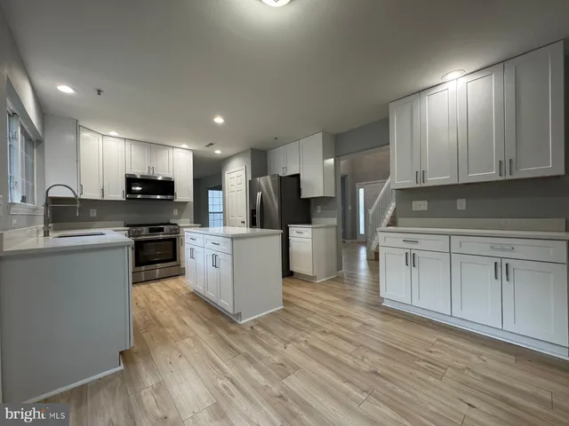 a kitchen with white cabinets and stainless steel appliances