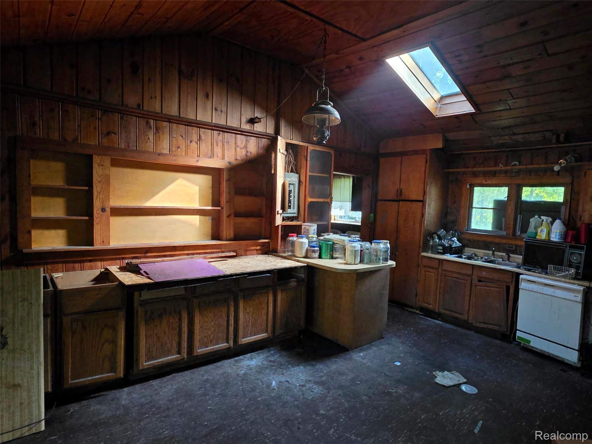 5420 Randy Drive Prescott, MI 48756 - Photo 21 of 31 Wood-paneled room featuring a sloped ceiling with a skylight, multiple windows, built-in cabinetry, and integrated shelving