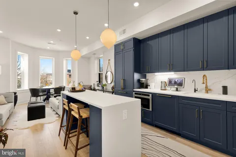a kitchen with a sink a stove a dining table and chairs