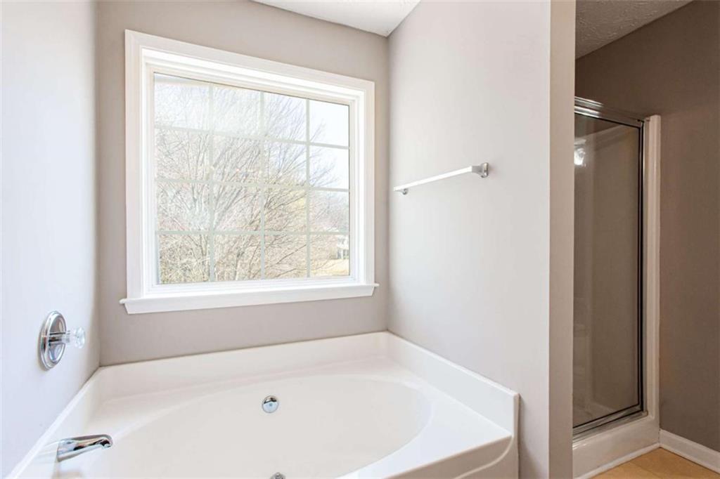 3721 Bogan Mill Road Northeast Buford, GA 30519 - Photo 27 of 58 a white bath tub sitting in a bathroom next to a window