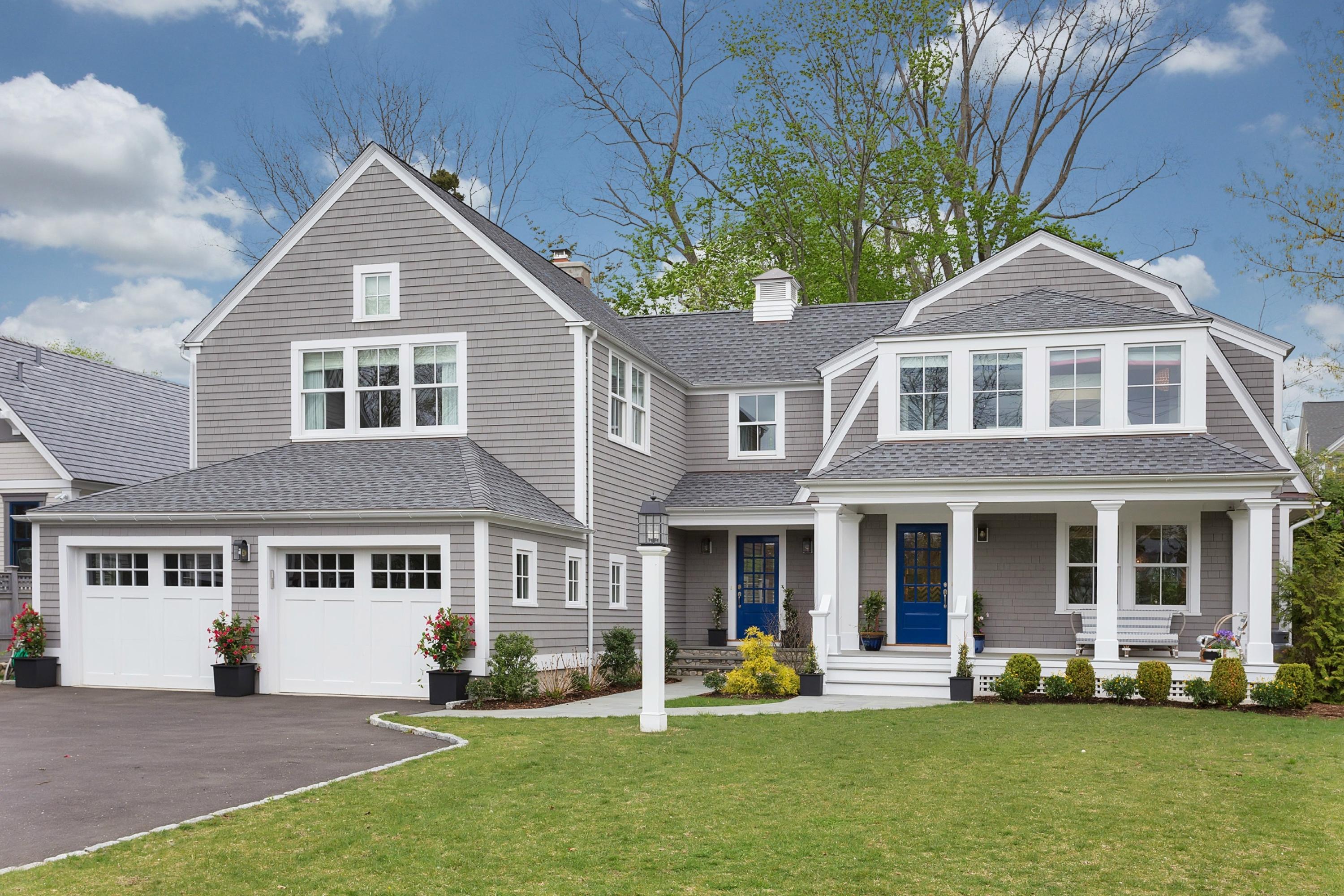 52 Roton Avenue Rowayton, CT 06853 - Photo 2 of 20 a front view of a house with a garden and trees