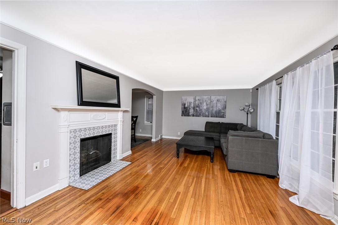 3699 Bainbridge Road Cleveland Heights, OH 44118 - Photo 5 of 37 Living area featuring wood-finish flooring, a white mantel, and a tiled fireplace surround