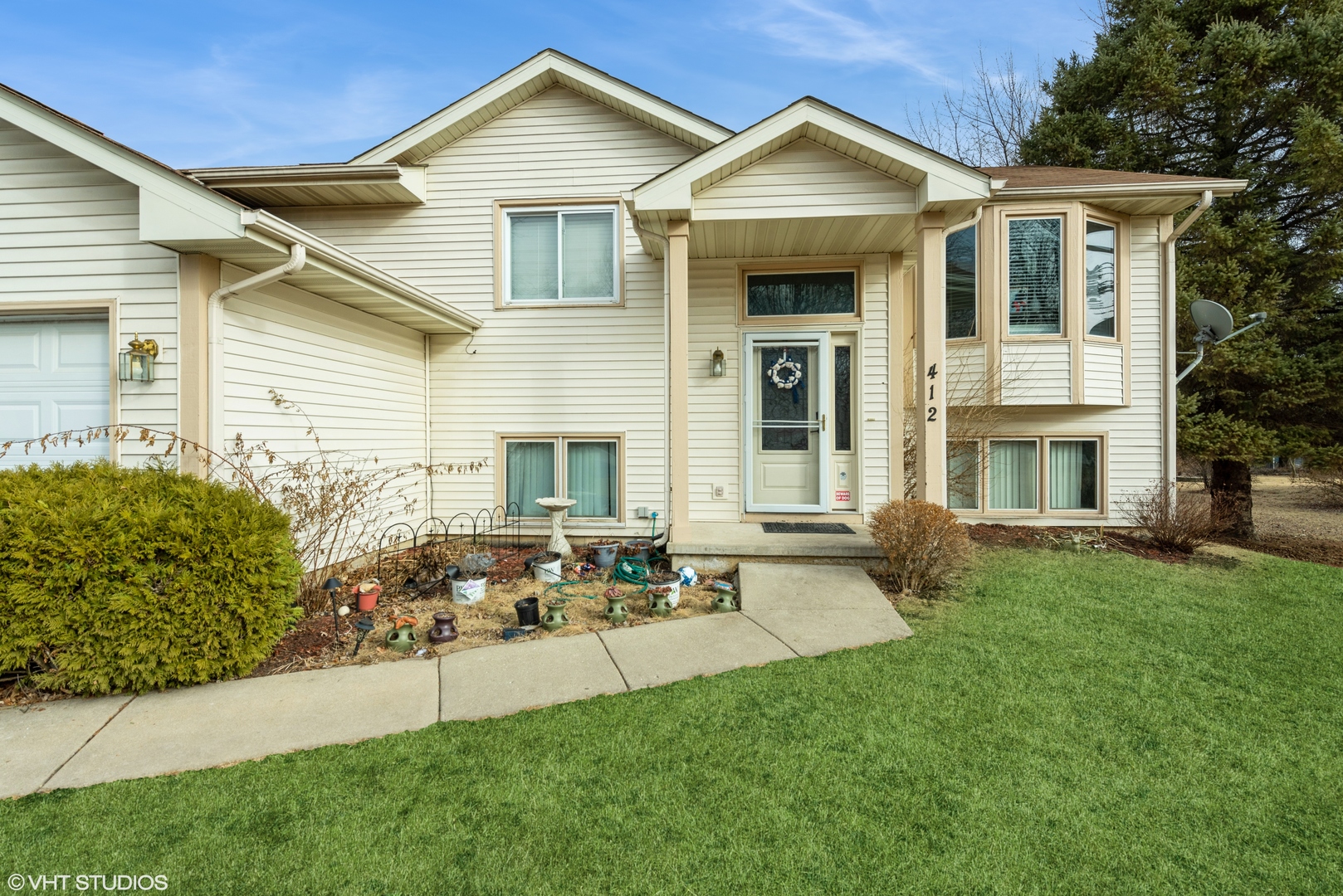 412 Lamplighter Loop Southeast Poplar Grove, IL 61065 - Photo 1 of 23 a front view of a house with garden