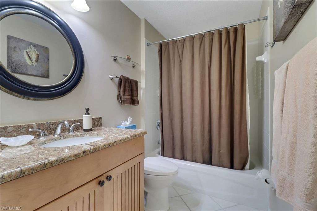 5325 Andover Drive, Unit 101 Naples, FL 34110 - Photo 16 of 25 Full bathroom with tile patterned floors, shower / bath combo with shower curtain, vanity, and toilet
