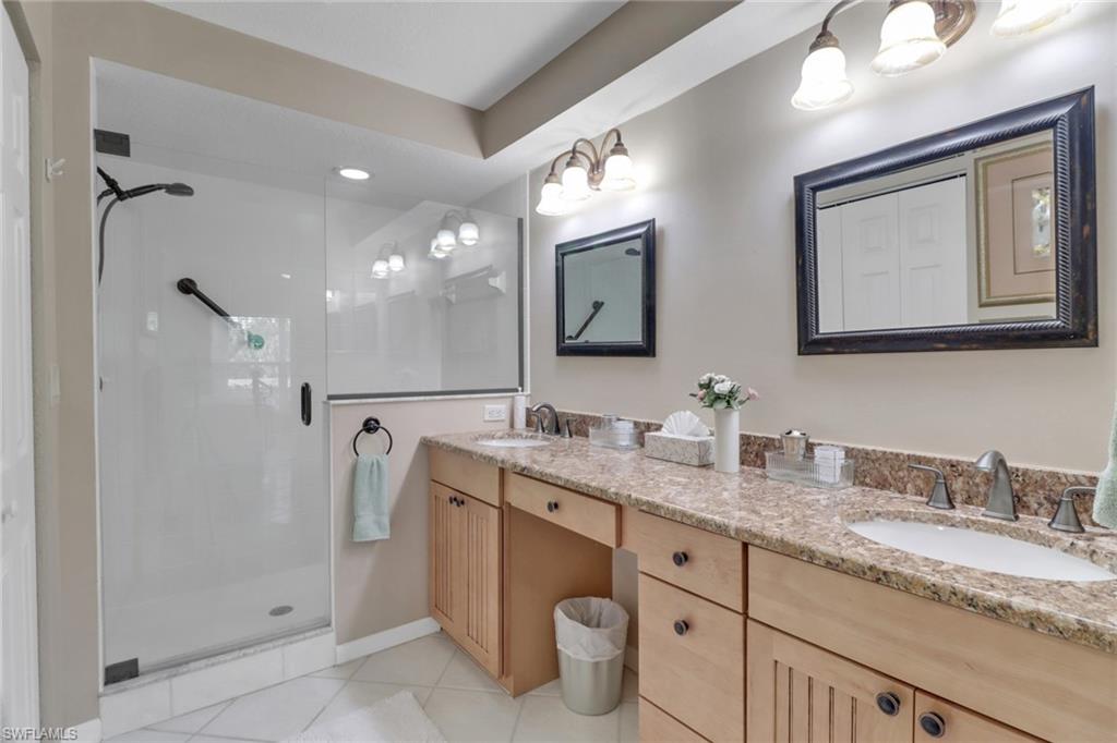 5325 Andover Drive, Unit 101 Naples, FL 34110 - Photo 19 of 25 Bathroom featuring tile patterned floors, vanity, and a shower with door