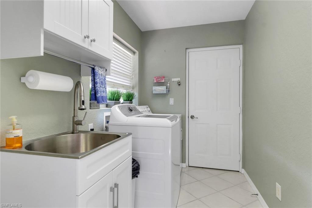 5325 Andover Drive, Unit 101 Naples, FL 34110 - Photo 20 of 25 Washroom with light tile patterned flooring, cabinets, separate washer and dryer, and sink