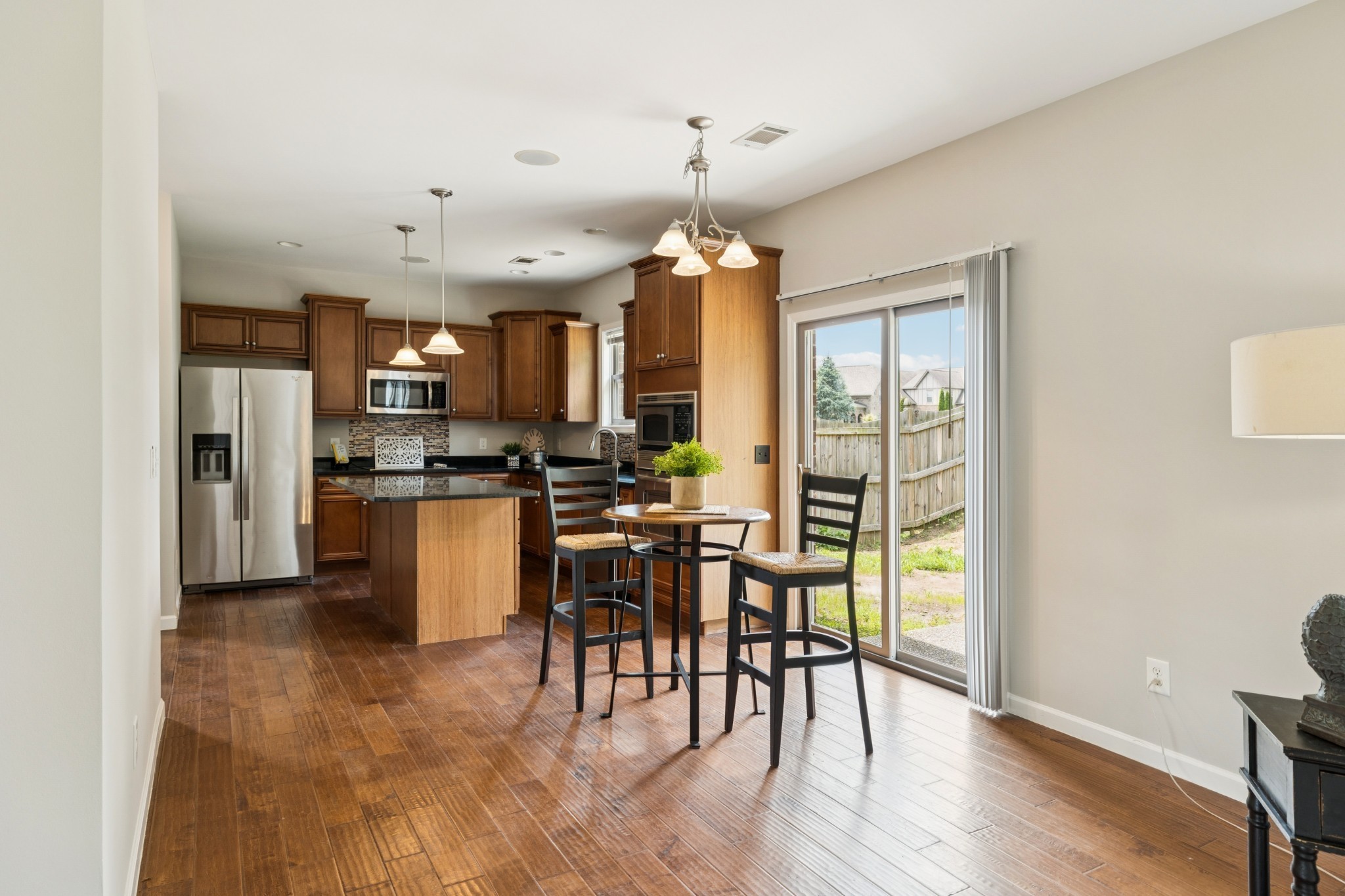 2040 Belshire Way Spring Hill, TN 37174 - Photo 20 of 74 a kitchen with stainless steel appliances kitchen island granite countertop a refrigerator a stove a dining table and chairs with wooden floor
