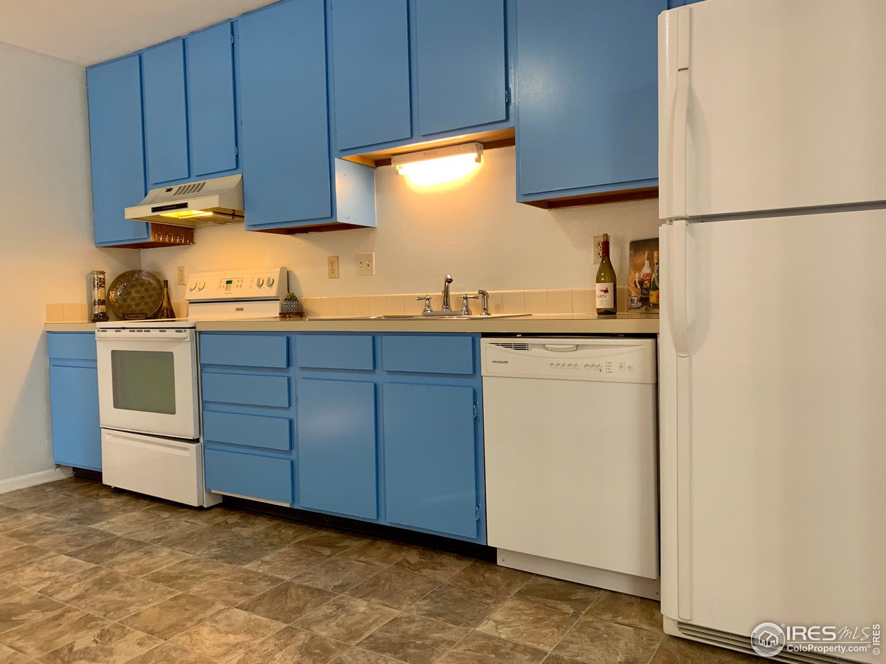 1672 Riverside Avenue, Unit 116 Fort Collins, CO 80525 - Photo 15 of 39 a kitchen with stainless steel appliances granite countertop a sink a stove and a refrigerator with wooden cabinets