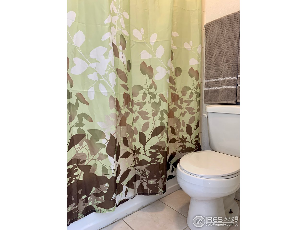 1672 Riverside Avenue, Unit 116 Fort Collins, CO 80525 - Photo 25 of 39 a white toilet sitting next to a shower curtain