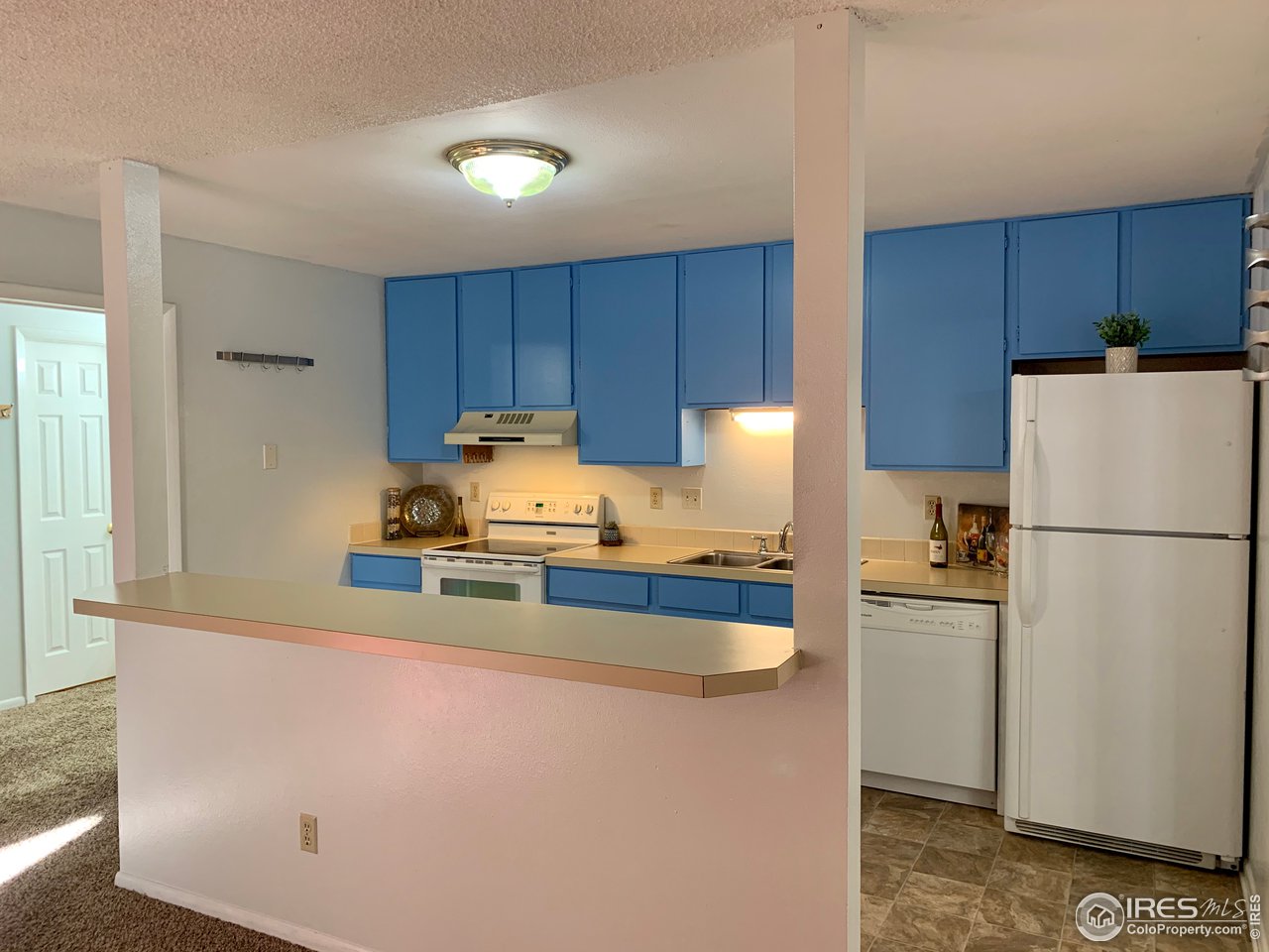 1672 Riverside Avenue, Unit 116 Fort Collins, CO 80525 - Photo 3 of 39 a kitchen with a refrigerator a stove a sink and cabinets