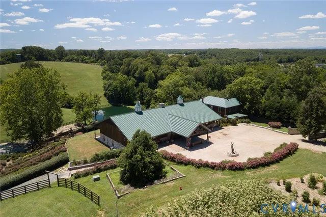 an aerial view of a house with a yard and lake