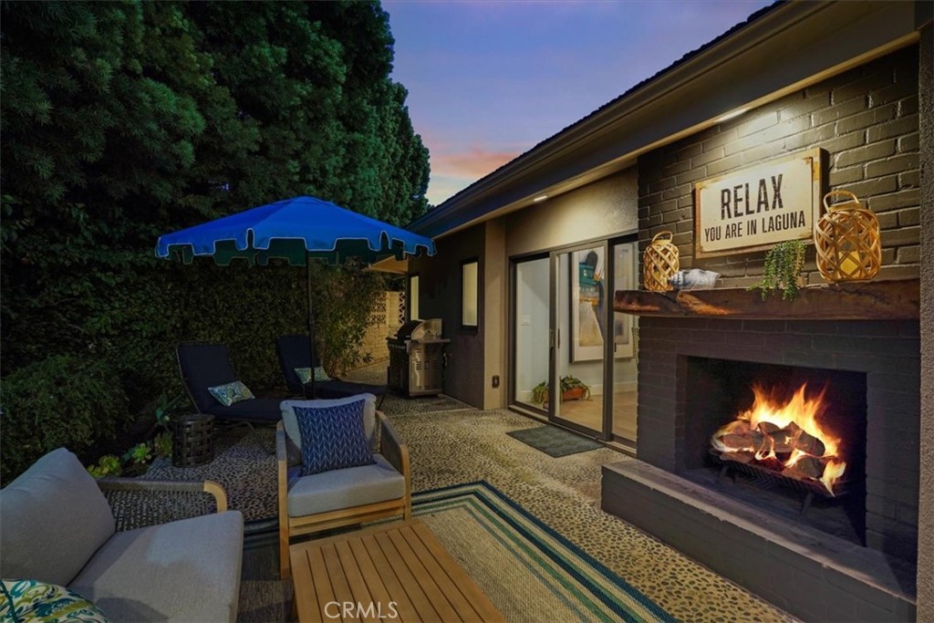 437 Emerald Bay Laguna Beach, CA 92651 - Photo 12 of 61 a patio with a fireplace a table and chairs