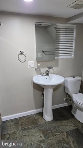 a bathroom with a sink toilet and mirror