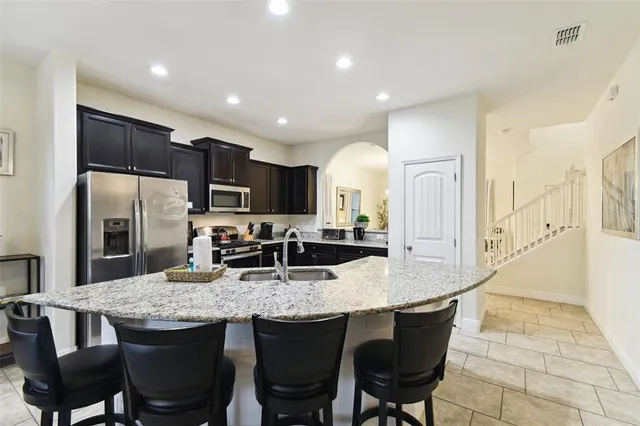a kitchen with stainless steel appliances granite countertop a sink a stove and a refrigerator