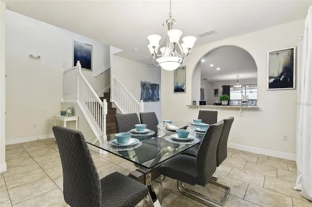 a living room with patio furniture and a chandelier
