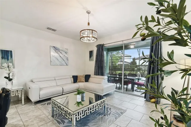 a living room with furniture a flat screen tv and a chandelier