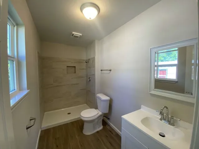 a bathroom with a toilet sink a mirror and shower
