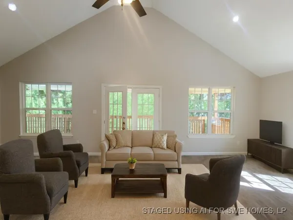 a living room with furniture a window and a flat screen tv