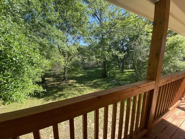 a view of a wooden deck with a yard