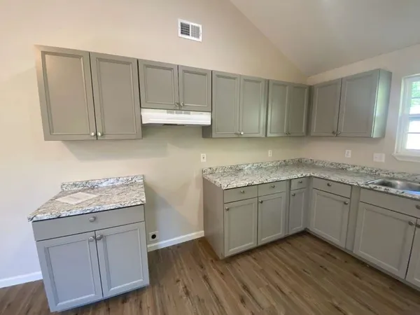 a kitchen with cabinets appliances and a wooden floor