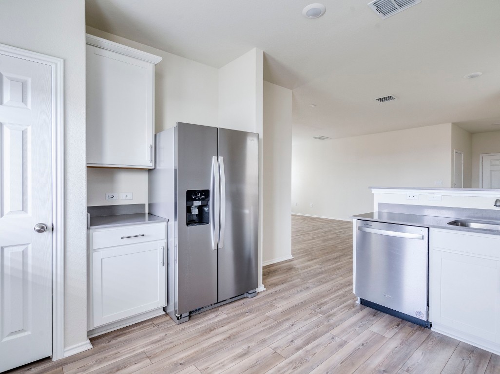 453 Tree Nut Loop Buda, TX 78610 - Photo 9 of 32 Contemporary white cabinetry pairs perfectly with gray counters.