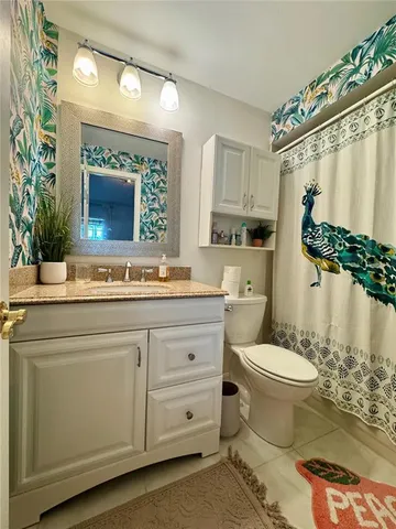 a bathroom with a granite countertop sink toilet mirror and a bathtub