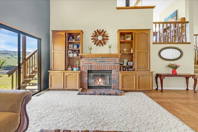 a living room with furniture a fireplace and a large window