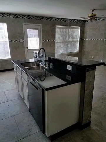 a kitchen with a sink and a stove top oven