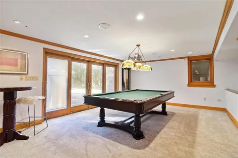 a living room with furniture pool table and a large window