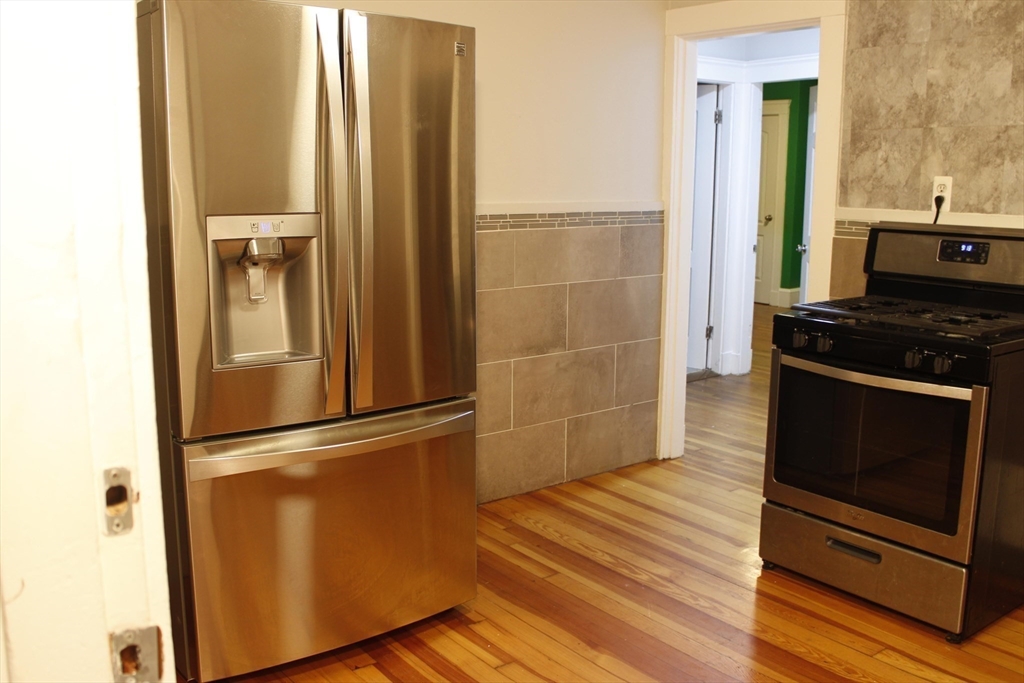 45-47 Coolidge Road, Unit 2 Boston, MA 02134 - Photo 5 of 11 a kitchen with a refrigerator and a stove top oven